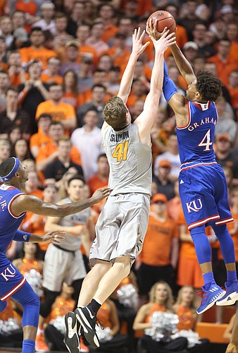 Kansas guard Devonte' Graham (4) gets up to snag a pass to Oklahoma State forward Mitchell Solomon (41) during the first half, Saturday, March 4, 2017 at Gallagher-Iba Arena. 