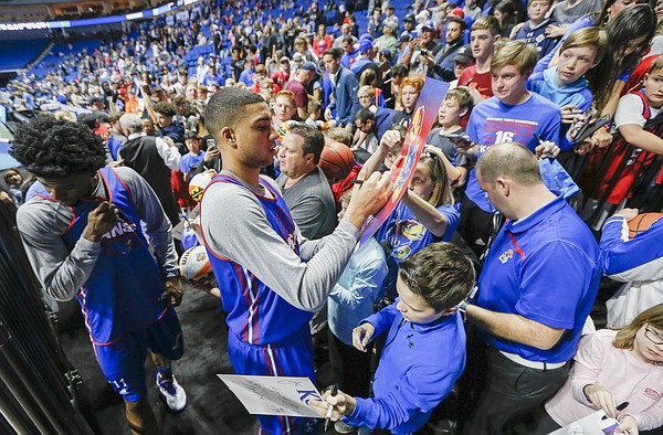 Kansas forward Landen Lucas signs a couple more autographs as the Jayhawks make their way from the court following a practice before fans on Thursday, March 16, 2017 at BOK Center in Tulsa, Oklahoma. At left is Kansas guard Josh Jackson.