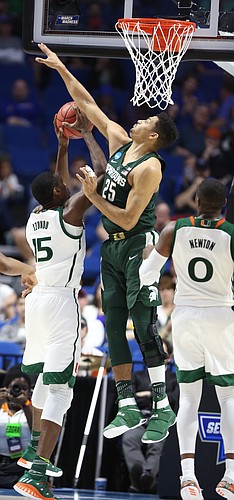 Michigan State forward Kenny Goins (25) gets up to defend against a shot by Miami center Ebuka Izundu (15) during the second half on Friday, March 17, 2017 at BOK Center in Tulsa, Oklahoma. At right is Miami guard Ja'Quan Newton (0).