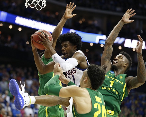 Kansas guard Josh Jackson (11) is swarmed in the paint by Oregon players including Oregon forward Dillon Brooks, front, and Oregon forward Jordan Bell (1) during the second half on Saturday, March 25, 2017 at Sprint Center.