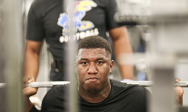 Sweat pours from the face of Kansas defensive tackle Daniel Wise as he prepares for a squat at the Anderson Family Football Complex on Thursday, June 29, 2017. 