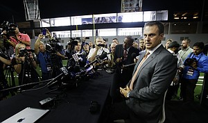 Texas head football coach Tom Herman takes a seat before speaking to reporters during the Big 12 NCAA college football media day in Frisco, Texas, Tuesday, July 18, 2017.