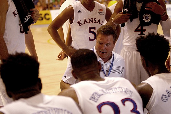 Kansas head coach Bill Self, center, gives suggestions to his players during a pause of a basketball game against HSC Roma in Rome, Wednesday, Aug. 2, 2017. (AP Photo/Riccardo De Luca)