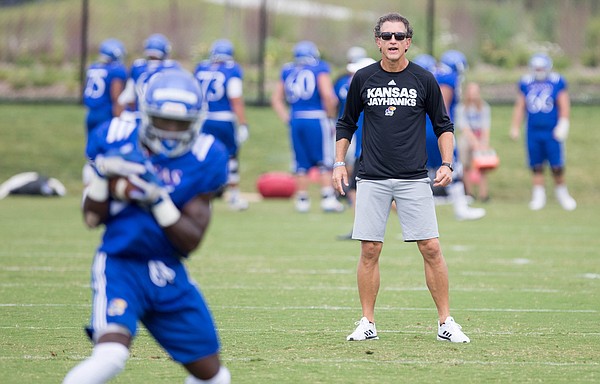 Kansas offensive coordinator and receivers coach Doug Meacham watches over a drill during practice on Monday, Aug. 14, 2017 at the grass fields adjacent to Hoglund Ballpark.
