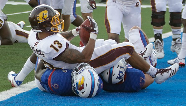 Central Michigan running back Devon Spalding (13) lands on two KU defender after scoring a touchdown in CMU’s win over KU Saturday, Sept. 9 at Memorial Stadium. 