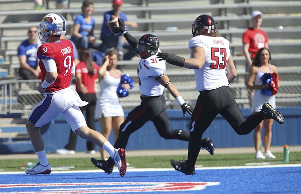 Kansas quarterback Carter Stanley (9) can't stop Texas Tech defensive back Justus Parker (31) as he runs into the end zone for a touchdown during the third quarter after an interception on Saturday, Oct. 7, 2017 at Memorial Stadium.