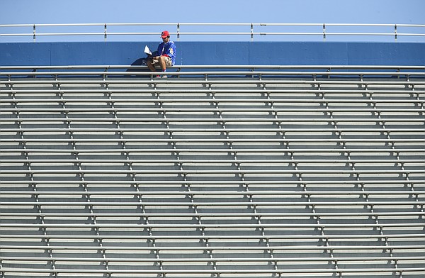 A Kansas fan looks through the game program from the top of the stands during the fourth quarter of KU's football game against Texas Tech, Saturday, Oct. 7, 2017 at Memorial Stadium. The Jayhawks lost, 65-19.