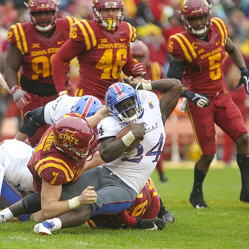 Kansas running back Taylor Martin (24) is wrestled to the ground by Iowa State linebacker Joel Lanning (7) during the third quarter on Saturday, Oct. 14, 2017 at Jack Trice Stadium in Ames, Iowa.