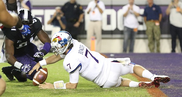 Kansas quarterback Peyton Bender (7) recovers a fumbled snap before TCU defensive tackle L.J. Collier (91) during the second quarter, Saturday, Oct. 21, 2017 at Amon G. Carter Stadium in Fort Worth.