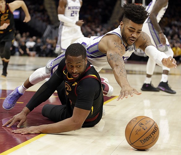 Sacramento Kings' Frank Mason III, right, and Cleveland Cavaliers' Dwyane Wade battle for a loose ball in the first half of an NBA basketball game, Wednesday, Dec. 6, 2017, in Cleveland. (AP Photo/Tony Dejak)