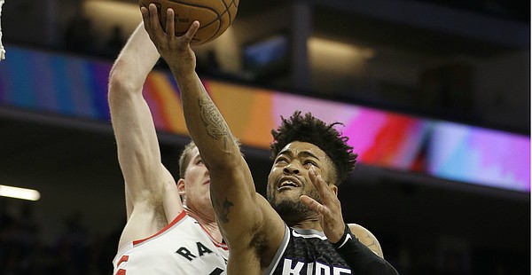 Sacramento Kings guard Frank Mason III, right, goes to the basket against Toronto Raptors center Jakob Poeltl, during the second half of an NBA basketball game, Sunday, Dec. 10, 2017, in Sacramento, Calif. The Raptors won 102-87. (AP Photo/Rich Pedroncelli)

