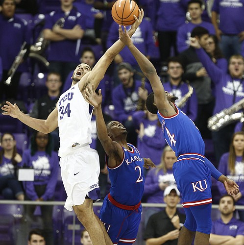 Kansas guard Lagerald Vick (2) and Kansas guard Malik Newman (14) compete for a rebound with TCU guard Kenrich Williams (34) during the first half, Saturday, Jan. 6, 2018 at Schollmaier Arena.