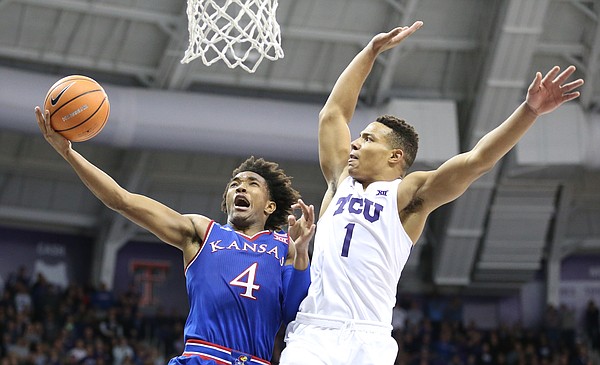 Kansas guard Devonte' Graham (4) goes to the bucket and is fouled hard by TCU guard Desmond Bane (1) late in the second half, Saturday, Jan. 6, 2018 at Schollmaier Arena.