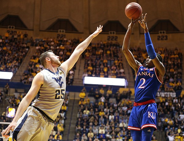Kansas guard Lagerald Vick (2) puts up a three over West Virginia forward Maciej Bender (25) during the first half, Monday, Jan. 15, 2018 at WVU Coliseum in Morgantown, West Virginia.
