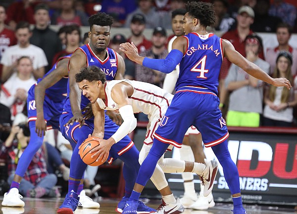 Kansas guard Devonte' Graham (4) and Kansas center Udoka Azubuike (35) look to tie up Oklahoma guard Trae Young (11) during the first half at Lloyd Noble Center on Tuesday, Jan. 23, 2018 in Norman, Oklahoma.