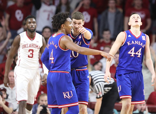 Kansas guard Sviatoslav Mykhailiuk (10) and Kansas guard Devonte' Graham (4) come together for a talk during the first half at Lloyd Noble Center on Tuesday, Jan. 23, 2018 in Norman, Oklahoma.