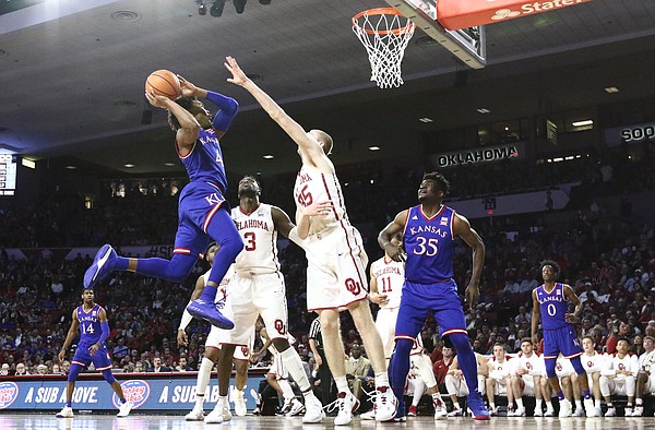 Kansas guard Devonte' Graham (4) comes in for a shot against Oklahoma forward Brady Manek (35) during the first half at Lloyd Noble Center on Tuesday, Jan. 23, 2018 in Norman, Oklahoma.