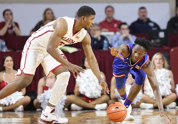 Kansas guard Marcus Garrett (0) can't quite get to a loose ball as it is scooped up by Oklahoma guard Christian James (0) during the second half at Lloyd Noble Center on Tuesday, Jan. 23, 2018 in Norman, Oklahoma.