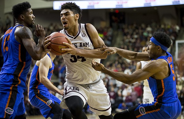 Texas A&M center Tyler Davis (34) tries to drive the lane against Florida forward Kevarrius Hayes (13) and guard KeVaughn Allen (5) during the first half of an NCAA college basketball game Tuesday, Jan. 2, 2018, in College Station, Texas.