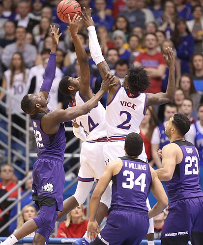 Kansas guard Malik Newman (14) and Kansas guard Lagerald Vick (2) fight for a rebound with TCU forward Kouat Noi (12) during the first half on Tuesday, Feb. 6, 2018 at Allen Fieldhouse.