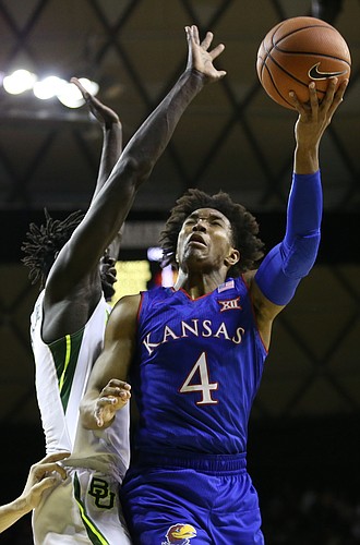 Kansas guard Devonte' Graham (4) is fouled by Baylor Bears forward Jo Lual-Acuil Jr. (0) on his way to the bucket during the first half, Saturday, Feb. 11, 2018 at Ferrell Center in Waco, Texas.