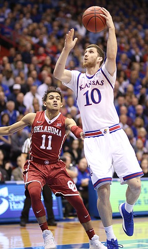 Kansas guard Sviatoslav Mykhailiuk (10) turns to the bucket past Oklahoma guard Trae Young (11) during the first half, Monday, Feb. 19, 2018 at Allen Fieldhouse.