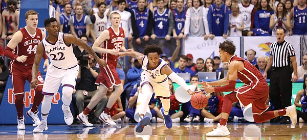 Kansas guard Devonte' Graham (4) strips a pass going to Oklahoma guard Trae Young (11) during the second half, Monday, Feb. 19, 2018 at Allen Fieldhouse.
