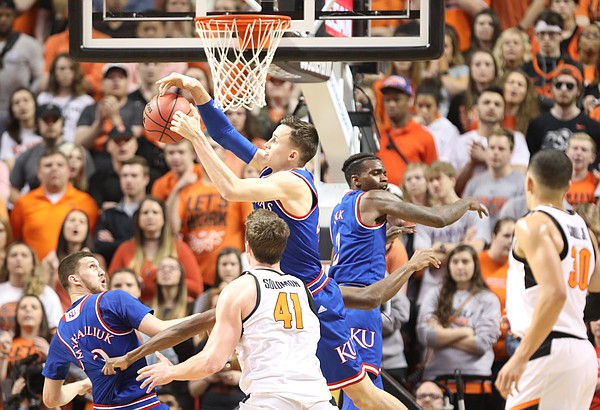 Kansas forward Mitch Lightfoot (44) pulls a rebound from Oklahoma State forward Mitchell Solomon (41) during the second half, Saturday, March 3, 2018 at Gallagher-Iba Arena, in Stillwater, Okla.