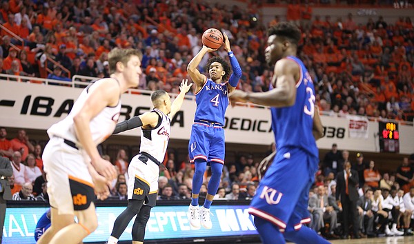 Kansas guard Devonte' Graham (4) pulls up for a three against Oklahoma State guard Kendall Smith (1) during the second half, Saturday, March 3, 2018 at Gallagher-Iba Arena, in Stillwater, Okla.