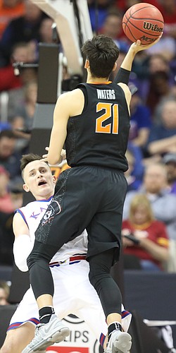 Kansas forward Mitch Lightfoot (44) takes a charge from Oklahoma State guard Lindy Waters III (21) during the second half, Thursday, March 8, 2018 at Sprint Center in Kansas City, Mo.