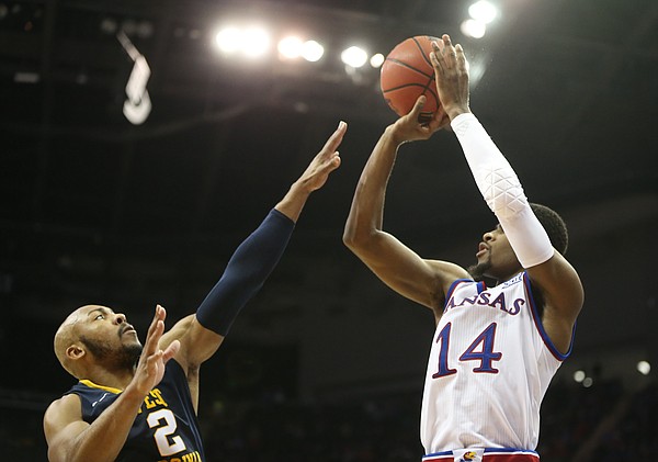 Kansas guard Malik Newman (14) puts up a three from the corner over West Virginia guard Jevon Carter (2) during the second half, Saturday, March 10, 2018 at Sprint Center in Kansas City, Mo.
