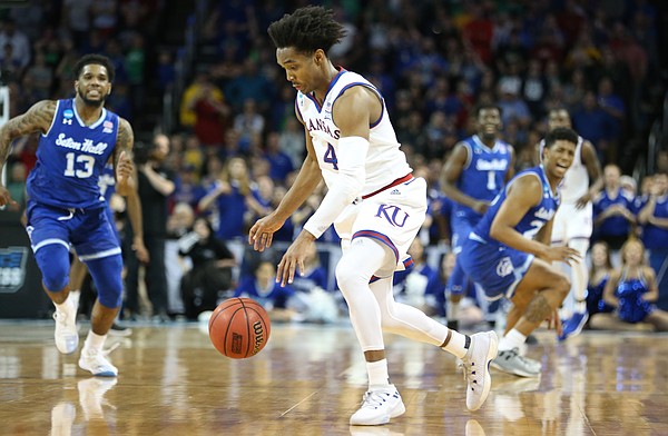 Kansas guard Devonte' Graham (4) comes away with a ball that was nearly stolen late in the second half, Saturday, March 17, 2018 in Wichita, Kan.