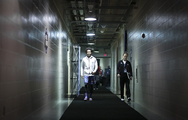 Kansas guard Devonte' Graham heads down a hallway to the team locker room during a day of practices and press conferences on Thursday, March 22, 2018 at CenturyLink Center in Omaha, Neb.