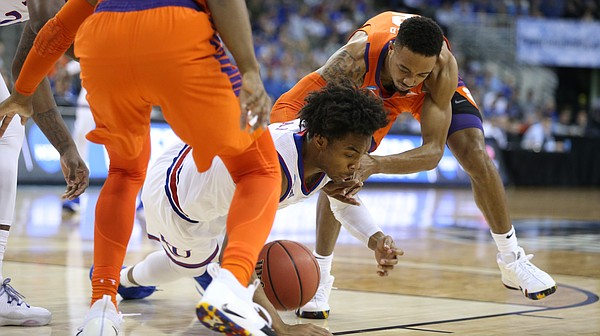 Kansas guard Devonte' Graham (4) hits the ground for a ball with Clemson guard Marcquise Reed (2) during the first half, Friday, March 23, 2018 at CenturyLink Center in Omaha, Neb.