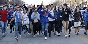 Shortly after the end of the KU-Duke game, Jayhawk fans run out of bars and down Massachusetts St., to celebrate Sunday, March 25, after the KU men’s basketball team’s NCAA tournament win over Duke Sunday to advance to the Final Four next week in San Antonio, TX. 