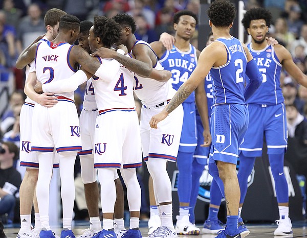 The Jayhawks and Blue Devils huddle up during the first half, Sunday, March 25, 2018 at CenturyLink Center in Omaha, Neb.