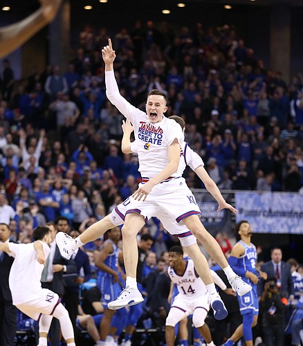 Kansas forward Mitch Lightfoot and Kansas guard Sviatoslav Mykhailiuk (10) celebrate in midair as the seconds after beating Duke in overtime to go to the Final Four on Sunday in Omaha, Neb.