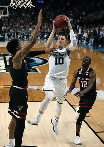 Villanova's Donte DiVincenzo, center, drives between Texas Tech's Justin Gray, left, and Keenan Evans, right, during the first half of an NCAA men's college basketball tournament regional final, Sunday, March 25, 2018, in Boston.