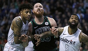 Boston Celtics center Aron Baynes, center, and Washington Wizards forwards Markieff Morris (5) and Kelly Oubre Jr., left, wait for a rebound during the first quarter of an NBA basketball game in Boston, Wednesday, March 14, 2018. (AP Photo/Charles Krupa)