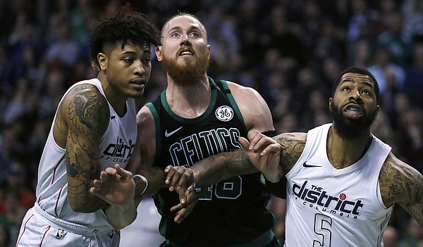 Boston Celtics center Aron Baynes, center, and Washington Wizards forwards Markieff Morris (5) and Kelly Oubre Jr., left, wait for a rebound during the first quarter of an NBA basketball game in Boston, Wednesday, March 14, 2018. (AP Photo/Charles Krupa)