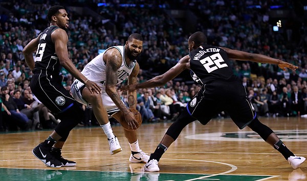 Boston Celtics forward Marcus Morris, center, drives to the basket between Milwaukee Bucks forward Khris Middleton (22) and guard Sterling Brown, right, during the fourth of Game 2 of an NBA basketball first-round playoff series in Boston, Tuesday, April 17, 2018. The Celtics defeated the Bucks 120-106. (AP Photo/Charles Krupa)