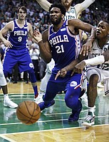 Philadelphia 76ers center Joel Embiid (21) drops to the floor as the ball bounces out of bounds after hitting him, as Boston Celtics guard Terry Rozier, right, points during the final seconds of Game 5 of an NBA basketball playoff series in Boston, Wednesday, May 9, 2018. The turnover helped the Celtics keep the lead as they defeated the 76ers 114-112. (AP Photo/Charles Krupa)