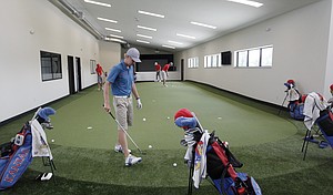 KU senior Daniel Sutton, foreground, and other members of the KU golf team practice putting inside the new KU golf facility at the Jayhawk Club, formerly the Alvamar Country Club. The team is the 15th seed in the NCAA Men’s Golf Championships, which begin Friday in Stillwater, Okla.