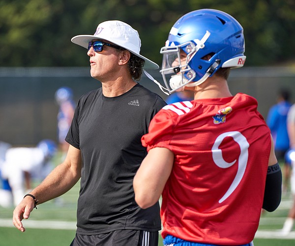Kansas football offensive coordinator and quarterbacks coach Doug Meacham and quarterback Carter Stanley watch as a drill plays out in front of them during a preseason practice on Aug. 4, 2018.