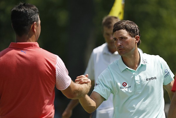Gary Woodland, left, shakes hands with Kevin Kisner, right, on the ninth green after they finished the second round of the PGA Championship golf tournament at Bellerive Country Club, Friday, Aug. 10, 2018, in St. Louis. (AP Photo/Brynn Anderson)