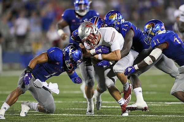 Nicholls State quarterback Chase Fourcade (9) is swarmed by Kansas players during overtime in an NCAA college football game in Lawrence, Kan., Saturday, Sept. 1, 2018. (AP Photo/Reed Hoffmann)