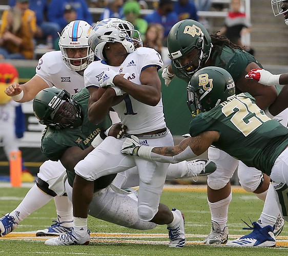 Kansas running back Pooka Williams Jr. (1) has his head turned on a penalty against a Baylor defender during the first half of an NCAA college football game, Saturday, Sept. 22, 2018, in Waco, Texas. 