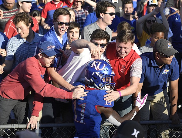 Kansas safety Mike Lee celebrated with fans after the win against TCU.