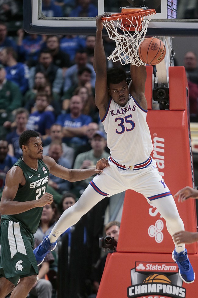 Kansas center Udoka Azubuike (35) dunks in front of Michigan State forward Xavier Tillman during the first half of an NCAA college basketball game at the Champions Classic on Tuesday, Nov. 6, 2018, in Indianapolis.