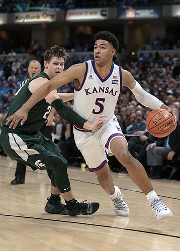 Kansas guard Quentin Grimes (5) goes around Michigan State guard Matt McQuaid (20) in the second half of an NCAA college basketball game at the Champions Classic on Tuesday, Nov. 6, 2018, in Indianapolis. Kansas won. 92-87.